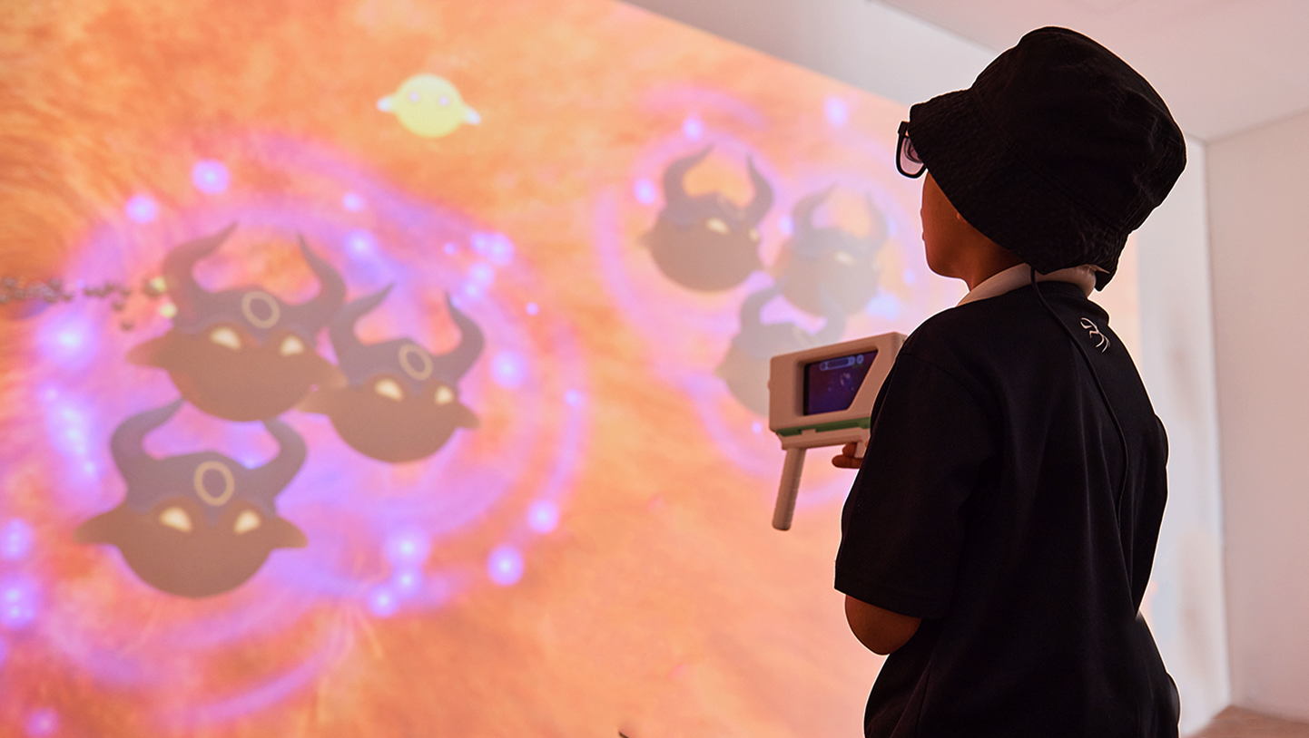 子どもが従来の抗がん剤と抗体医薬品の違いを表現したシューティングゲームをしている様子