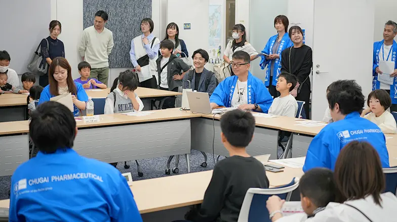 社員と子どもたちが模擬会議に参加している様子