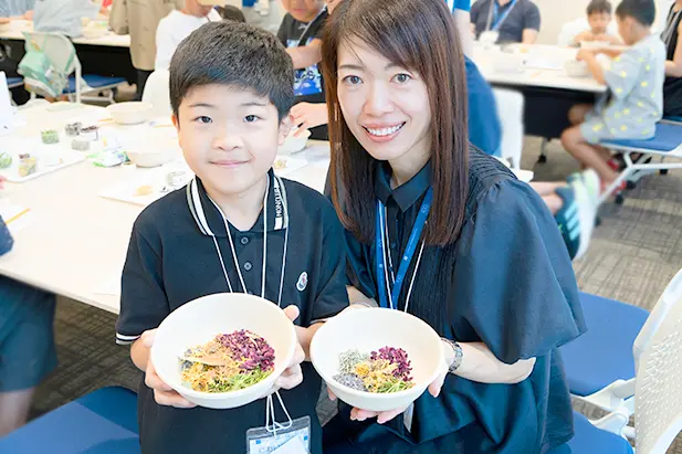 イベントで作ったくすりを手に笑顔を見せる親子