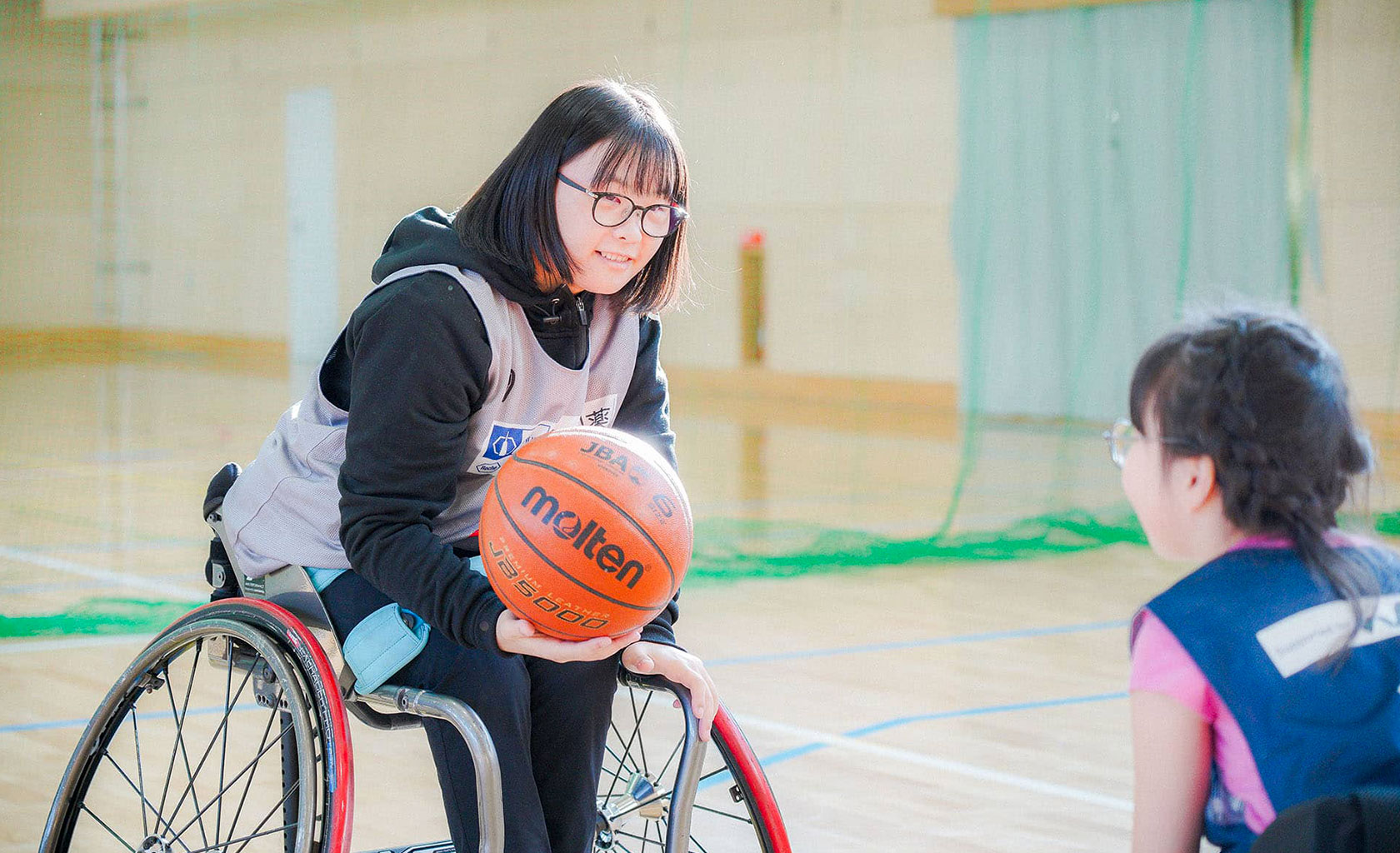 下の子にバスケットボールを教える様子