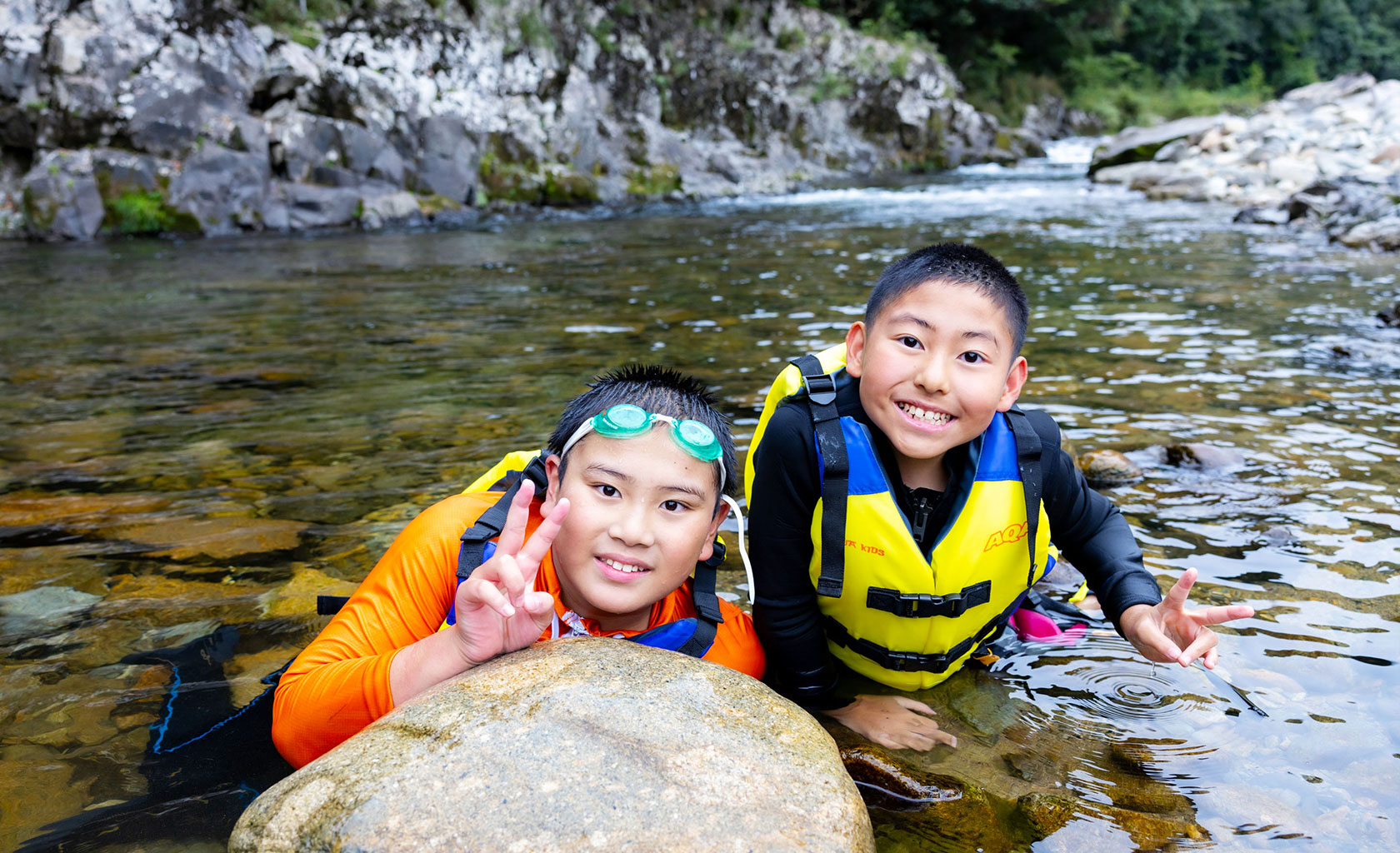 川でのアウトドアで笑顔の子どもたち